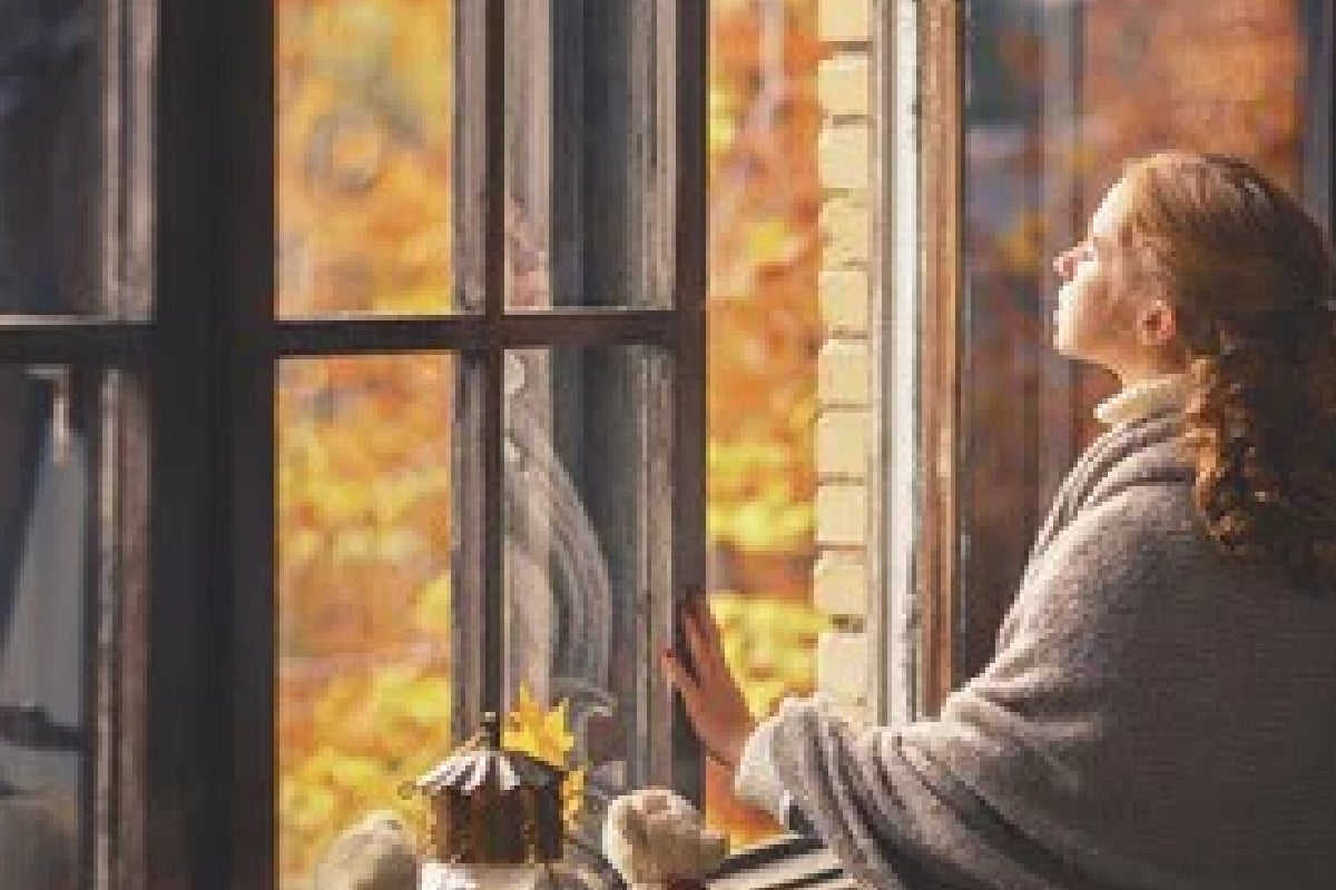 Vrouw in open raam met deken - frisse lucht